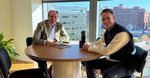 CEO Charlie Blackburn with Managing Director of North America Tom Bradley sitting at a table in the D.C. Office