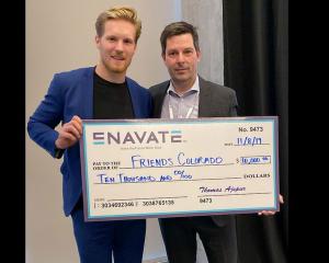 ENAVATE's Thomas Ajspur presents a check to Gabriel Landeskog, Friends Colorado ambassador