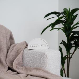 Shushiie baby sleep sound machine with adjustable dials for combining soothing sounds, displayed in a calm nursery setting.