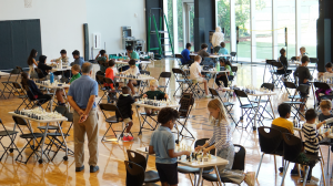young students playing chess in tournament