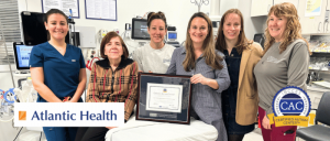 A group of healthcare professionals proudly hold a certification plaque, showcasing their achievement with Atlantic Health and Autism Center.