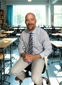 Jason Becker, founder of Elite Scholars Prep, standing in a classroom during a professional portrait.