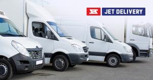 Four white delivery trucks of varying sizes and types