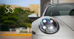 Close up of silver Porsche 911 Targa 4S from Sun and Speed in Cancun Mexico with out of focus trees in the background