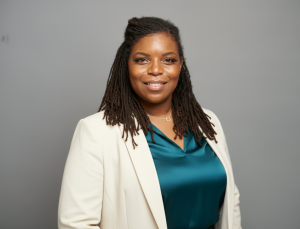 Natasha Broxton, founder of Alitura Group, photographed in a professional headshot wearing a cream blazer and teal blouse.