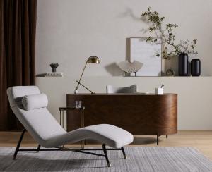 Modern luxury living room with gray sectional sofa, designer furniture, natural lighting from large windows, and Pacific Northwest landscape views demonstrating high-end interior design and premium home furnishings.