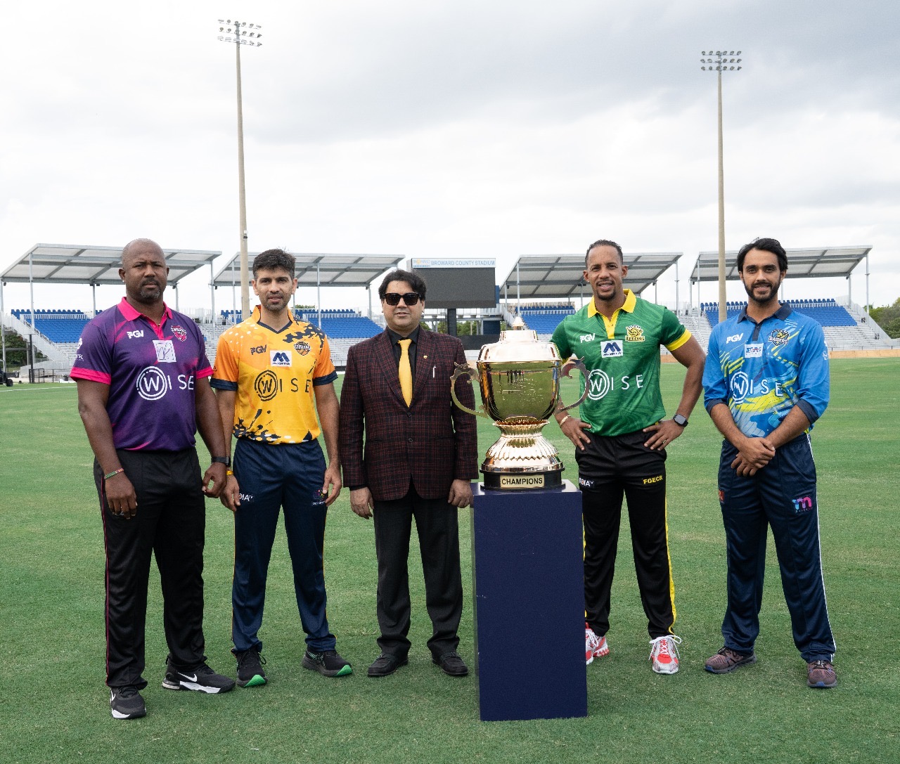 ChatGPT said: Brijesh Mathur of Pramanit Global Ventures USA Inc. (PGV) with Mayor’s New World T20 team captains and the championship trophy at Central Broward Park, Lauderhill, Florida.