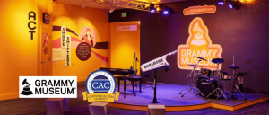 Interior of the Grammy Museum featuring a stage with instruments and colorful wall graphics highlighting music education initiatives.
