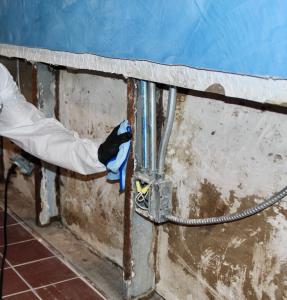 Flood cut exposing wall studs and electrical components during water damage restoration.