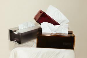 Refillable acrylic Blow Tissues boxes in berry, amber, and smoke with bamboo tissues pulled through the top, styled in a modern neutral setting.