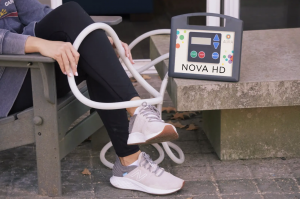The portable Nova HD+ device which provides a non-invasive, drug-free approach to supporting the body’s natural recovery process pictured on a clients leg