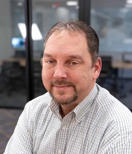 A man in a plaid button-down dress shirt.