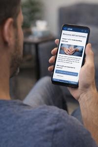 male looking at a mobile device and taking a microcourse on self care