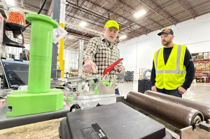 Two workers wearing safety gear standing at a workbench inside Centrotherm facility.
