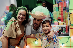 Picture of Rauw Alejandro with his arms around attendees at Regalos Pa’ Los Míos 2025