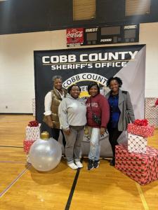 Volunteers stand before a Cobb County Sheriffs office backdrop