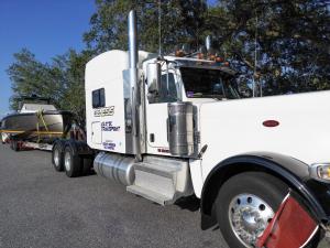 Luxury yacht carefully loaded for transport by Genesis Exotic Transport, demonstrating expert and insured boat transportation solutions.