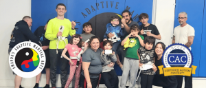 A diverse group poses together at a martial arts studio, showcasing teamwork and inclusion in a supportive environment.