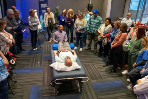 Live biomagnetism training session with participants gathered around a treatment table, observing a practical demonstration during a Dr. Garcia Biomagnetism educational program.