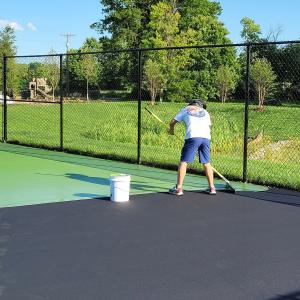 Applying athletic court surfacing on pickleball court