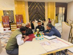 Mr. Praveen Tanwar in a strategic property meeting with clients, reviewing property data.