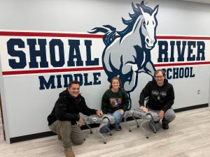 Teachers and staff at Shoal River Middle School interacting with Go2 Edu robot dogs