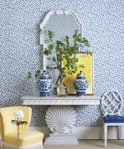 Ballard Designs clam shell base white console table by Designer Miles Redd with vases and a plant on it