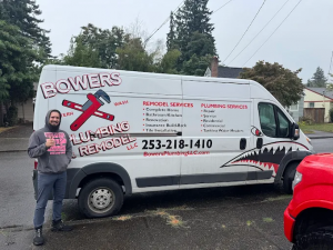 A Bowers Plumbing & Remodel technician standing next to a branded company service truck.