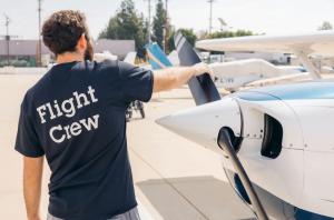Crew member doing pre-flight checks on propeller at LA Flight Academy in Van Nuys California