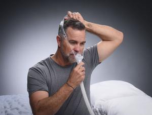 Man putting on the DeltaWave mask before bed.