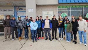 A group of volunteers from Marketing Agency Near You stand together in front of the United Way of Bucks County food distribution warehouse.