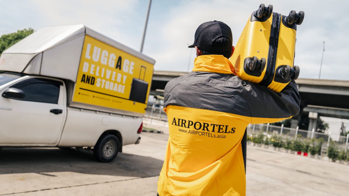A luggage delivery staff member transferring a suitcase to support hands-free travel, helping travelers move more freely across destinations in Thailand.