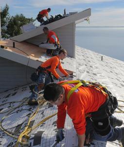 A Chase Construction North West, Inc. crew installing roofing materials on a residential home, representing the company’s services for customers across Pierce and King County.