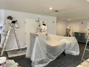 Professional painters from Build & Paint Portland performing interior home painting for a community project in Portland, Oregon.