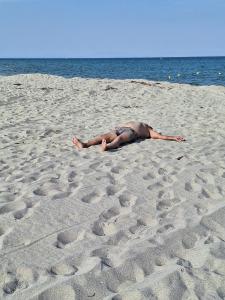 Mann sonnt sich allein auf langem Sandstrand: Griechenland Reisen weiß wohin – plant nach Wünschen, Kunden reisen bequem und entspannt