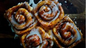 Glazed cinnamon rolls with visible cinnamon swirls and soft layered dough arranged closely together