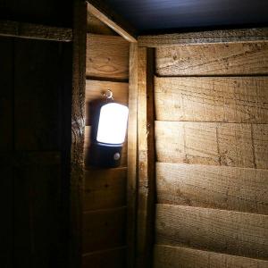 Small portable LED lantern mounted outside home at night