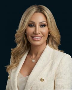 Professional headshot of Dr. Sydney Ceruto, neuroscience pioneer, founder and CEO of MindLAB Neuroscience, and author of "Rewire for Resilience: Heal Your Anxious Brain in 30 Days," wearing a cream blazer against a dark blue background.