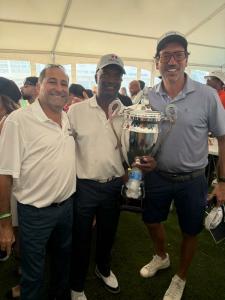 Don Wright celebrates his first-place finish at DJ Khaled’s ‘We The Best’ Golf Classic, proudly holding the championship trophy while representing Madison Insurance Group.
