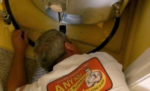 Any Hour technician inspecting water heater
