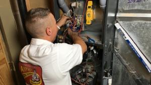 Any Hour technician performing a furnace tune-up