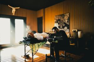 A photo of tattoo artist Dillon Forte working on a client in his Wimberley Texas studio