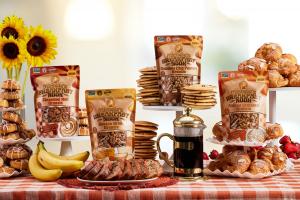 Michele's Breakfast Nook granola varieties featured on a table with the breakfasts that inspired them: Cinnamon Roll, Almond Croissant, Banana Bread and Chocolate Chip Pancake