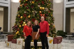 DBIA's regions team pose in front of a holiday tree