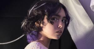 Headshot of Alisha Liston looking to her right providing a view of her purple peek-a-boo hair cut