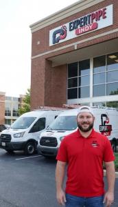 Service Manager of ExpertPipe Indy in Carmel Indiana stands in front of office and vans.