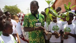 An educator wearing a LiThink badge teaching children wearing Plant-for-the-Planet t-shirts about tree planting.