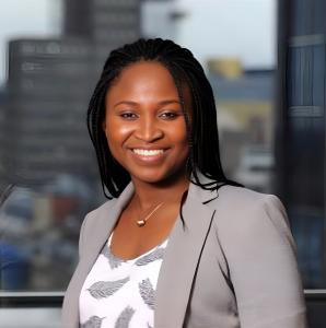 Destiny Pointer, founder of Arthur-Reese, standing in an office environment, smiling at the camera