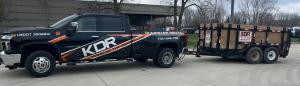 KDR Dumpster Rental truck towing multiple dumpster trailers for job site waste removal.