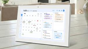 A high-definition concept rendering of the FotoCube AI Family Smart Calendar display, featuring a 15-inch sleek touchscreen showing a unified family schedule and the "Magic Frame" photo interface in a modern kitchen setting.